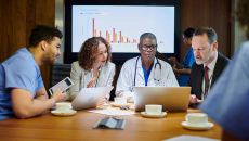 Medical professionals meeting with a graph in the background