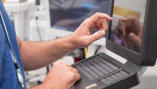 Healthcare worker using touchscreen computer terminal