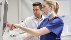Healthcare worker pointing to a screen with another in the background
