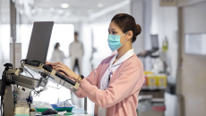 A nurse using a laptop to work on a medical report