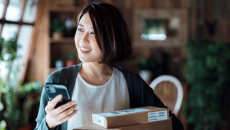 Person holding a package and smartphone