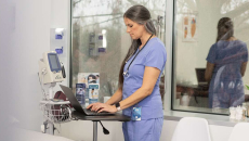 Healthcare worker using laptop in hospital room