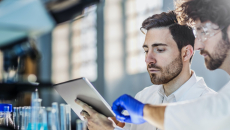Scientists working on a lab experiment using a digital tablet