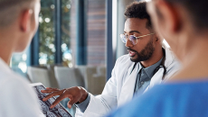 Healthcare professionals examine a brain scan on a tablet
