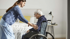 Healthcare worker assisting patient in wheelchair