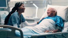 Healthcare worker talking to patient in hospital bed
