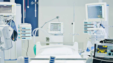 Empty hospital bed surrounded by monitoring equipment