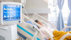 Patient in hospital bed with vital sign monitor