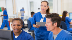 Nurses talking while looking at computer screen