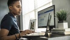 Office worker using laptop and external monitor