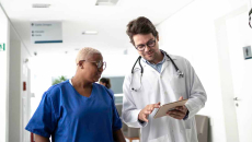 Doctor showing tablet to healthcare worker