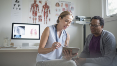 Doctor reviews data on a tablet with a patient