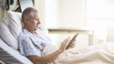 Patient using tablet in hospital bed