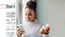 Smartphone user holding a pill bottle