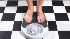 Feet on a scale on a black and white checkerboard floor