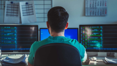 Healthcare worker looking at multiple monitors