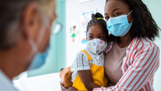 Patient and child in mask visiting doctor