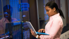 Person with laptop in a server room