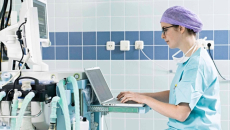 Clinician in scrubs at a hospital computer