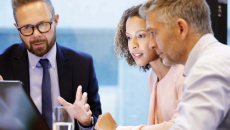 Executives meeting around a laptop
