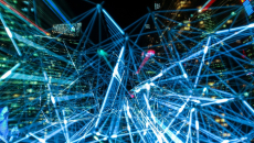 Beams of light shine between buildings.