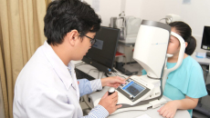 A FV Hospital doctor using the Myopia Master for screening a young patient