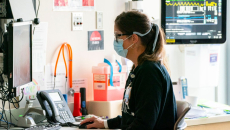 public health nurse examines data on a computer