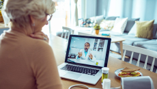 A person in home is having a telehealth appointment with a doctor via laptop.
