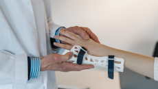 A doctor fitting a wrist brace on a patient
