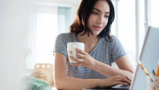 Person with mug using a laptop