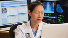 A doctor checking a patient's record on a laptop computer
