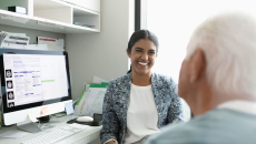 A smiling doctor facing a patient in a consultation