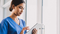 A clinician enters documentation on a tablet.