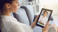 Person sits on couch while having a video visit with a mental health clinician