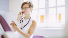 A doctor reviewing a patient's record on a digital tablet