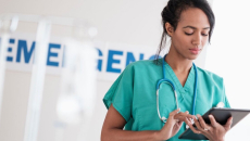 A nurse checking a patient file on a digital tablet