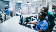 Nurses using a desktop computer in their station