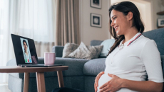 A pregnant person consulting with their doctor via video chat on a laptop