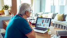 A senior person consulting with a doctor online on a laptop