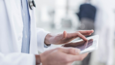 A doctor reviewing a patient's file on a digital tablet