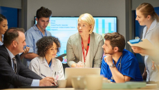 Hospital staff discuss around a conference table