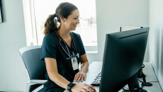 A doctor accessing a patient file on a desktop computer