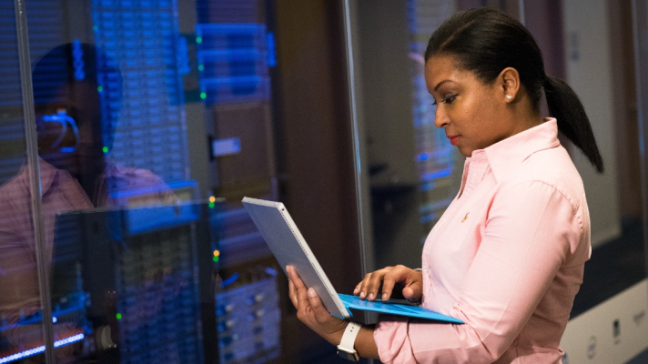 IT checks info on laptop in front of IT room