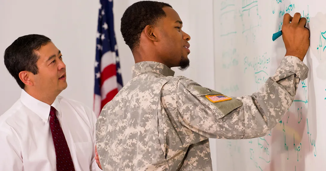 veteran draws on a whiteboard with a colleague veteran draws on a whiteboard with a colleague