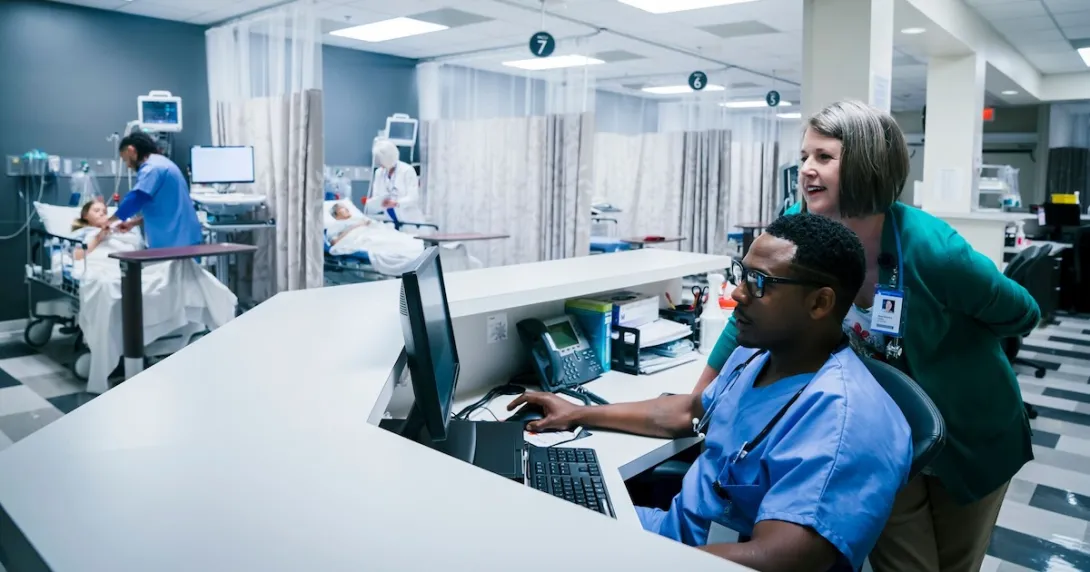 Nurses using a desktop computer in their station Nurses using a desktop computer in their station