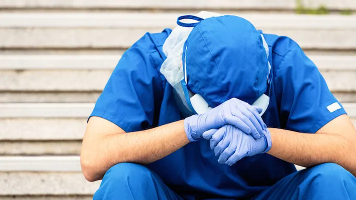 An exhausted person in PPE