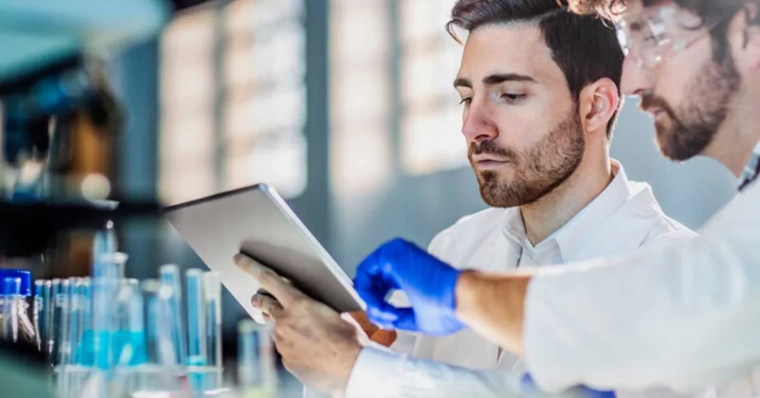 Two scientists use a tablet to review data