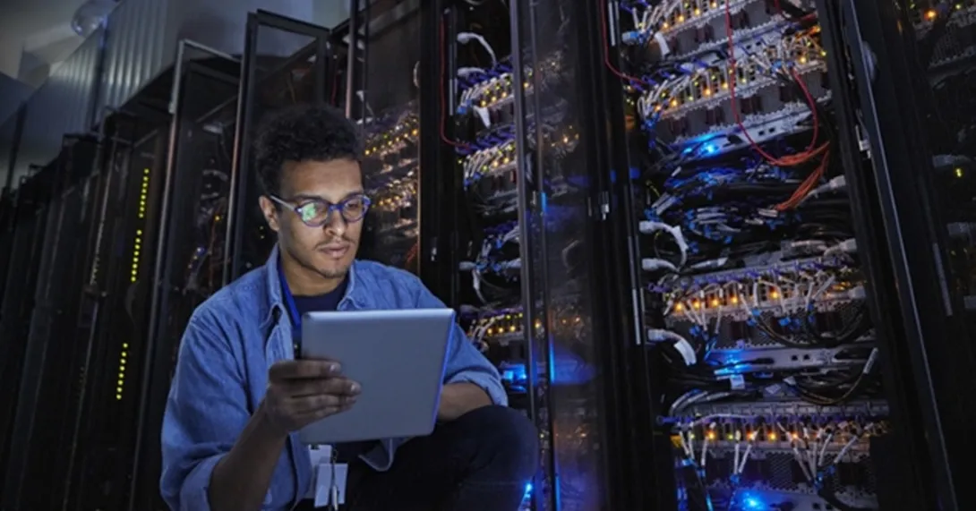 HIT computer engineer reviews security in a server room