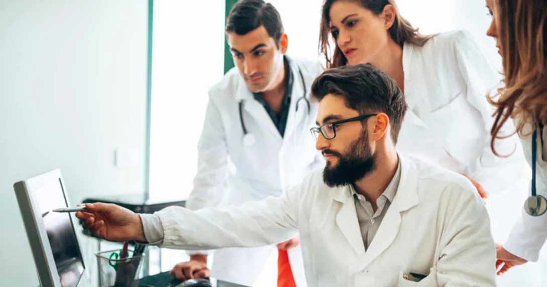 Group of clinical researchers gather around an EHR