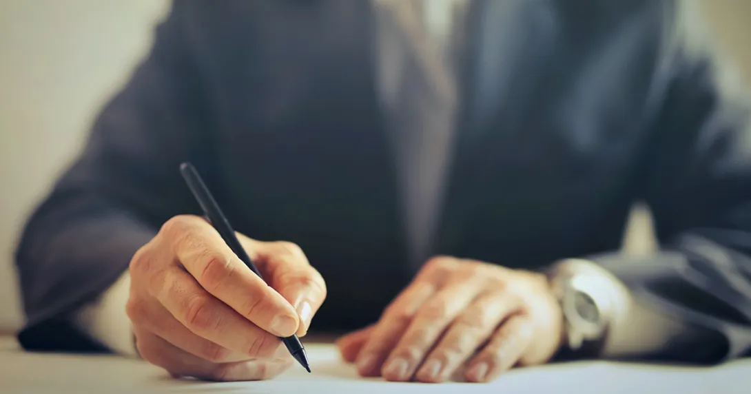 A person writing a letter